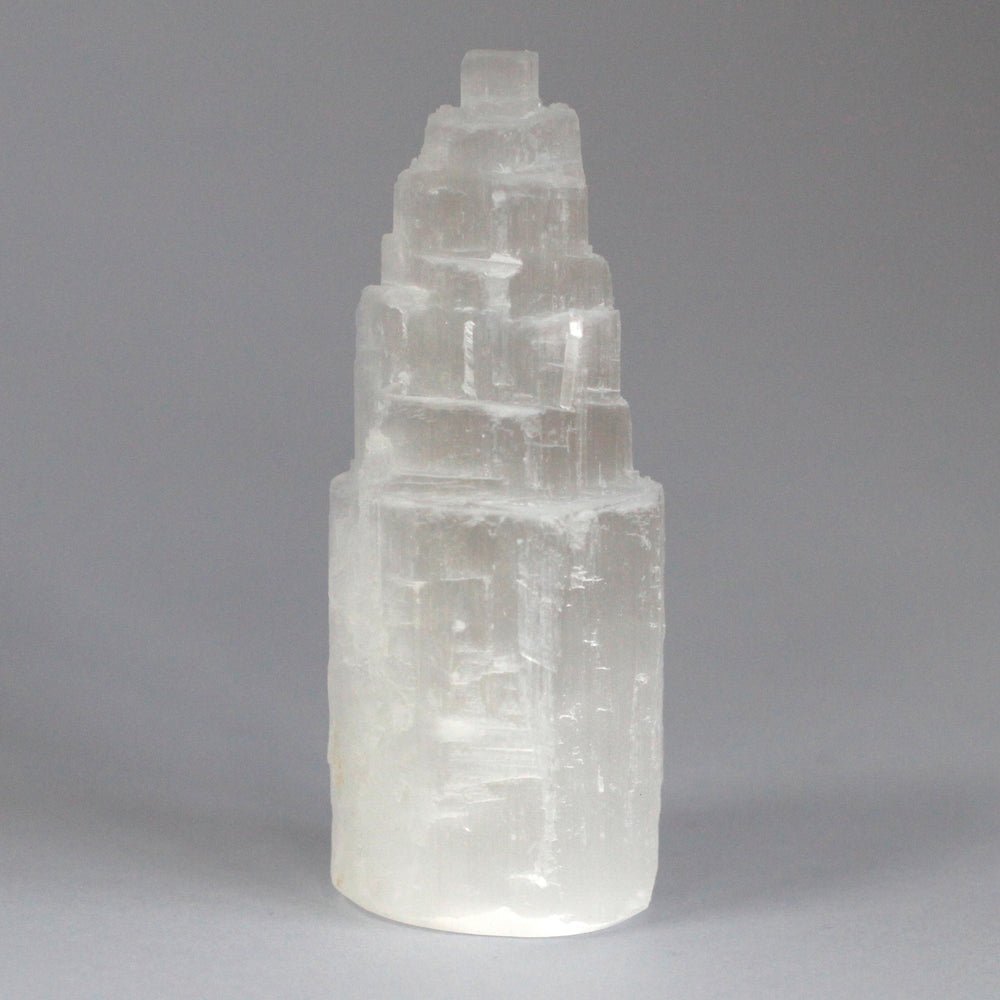 Torre de selenita blanca de 15 cm, escalonada y translúcida que irradia pureza - purifica y eleva la energía del ambiente.