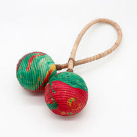 Sonajero Maracas de Doble Giro: doble esfera en fibras naturales y cáscaras, rojo y verde - ofrece ritmo y calma.