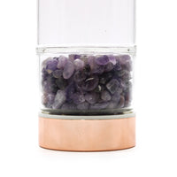 Botella de cristal para té: acabado oro rosa y amatista; cuerpo translúcido y tapa dorada; favorece calma al infusionar.