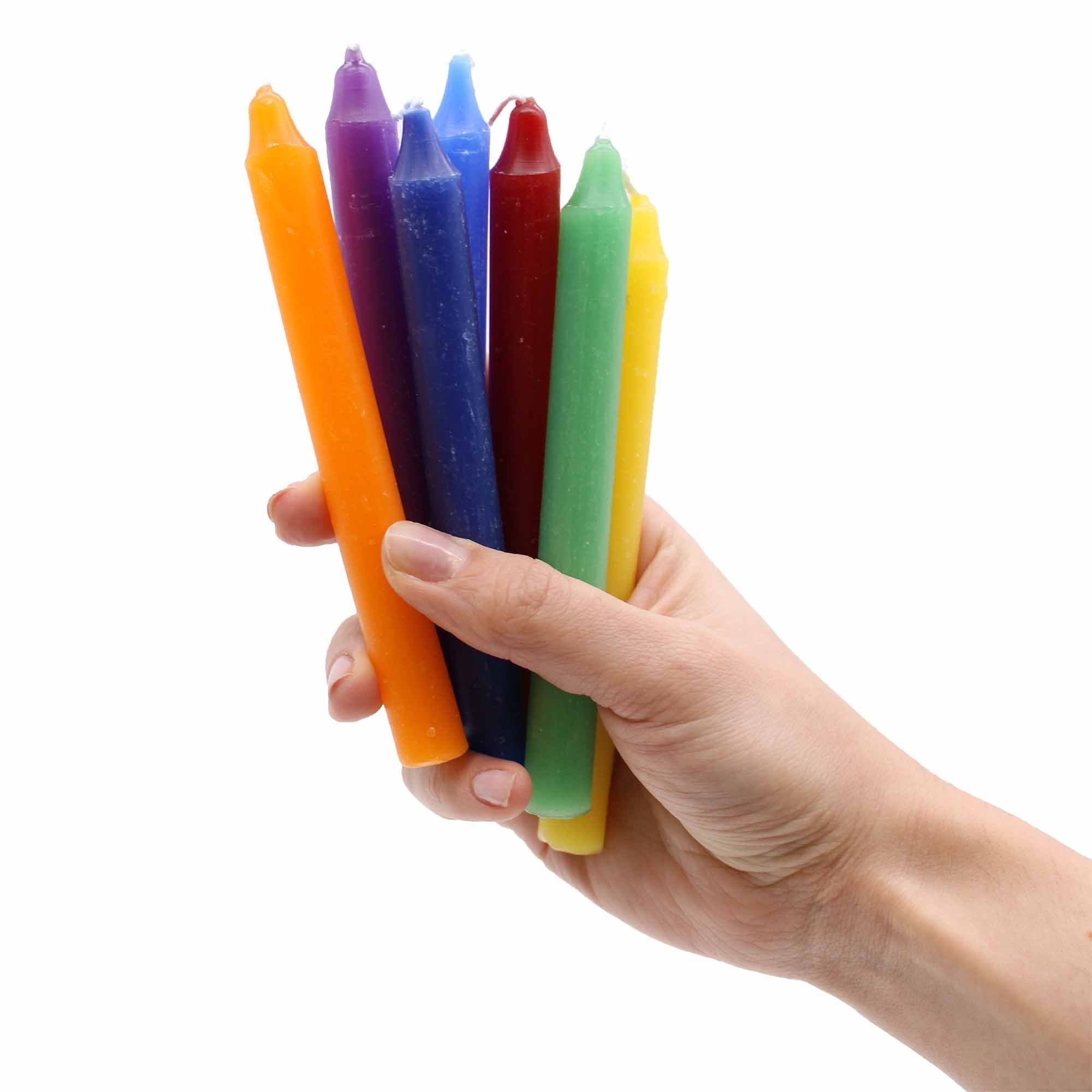 7 velas para activar los 7 chakras en fondo blanco en una mano