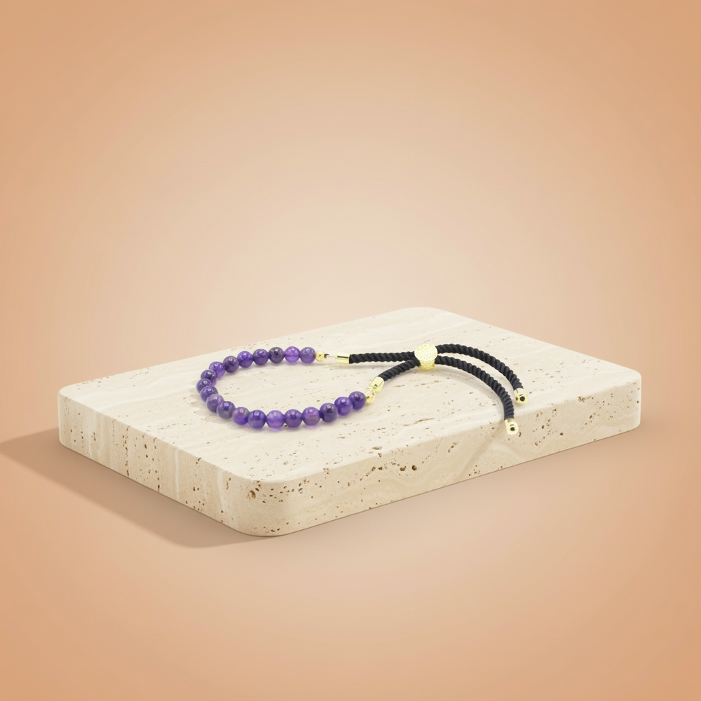 Pulsera de hilo negro con amatistas naturales en violeta y cierre ajustable — calma, protección y claridad espiritual.