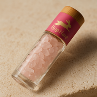Detalle mineral de Roll-On de Cuarzo Rosa: frasco de 10 ml con esfera, piedras rosas y tapa de bambú; compacto - amor y armonía