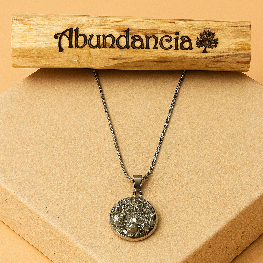 Palo santo Abundancia con colgante de pirita sobre base beige, imagen de producto 1:1.