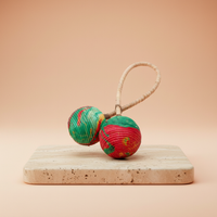 Sonajero Maracas de Doble Giro: doble esfera en fibras naturales y cáscaras, rojo y verde - ofrece ritmo y calma.